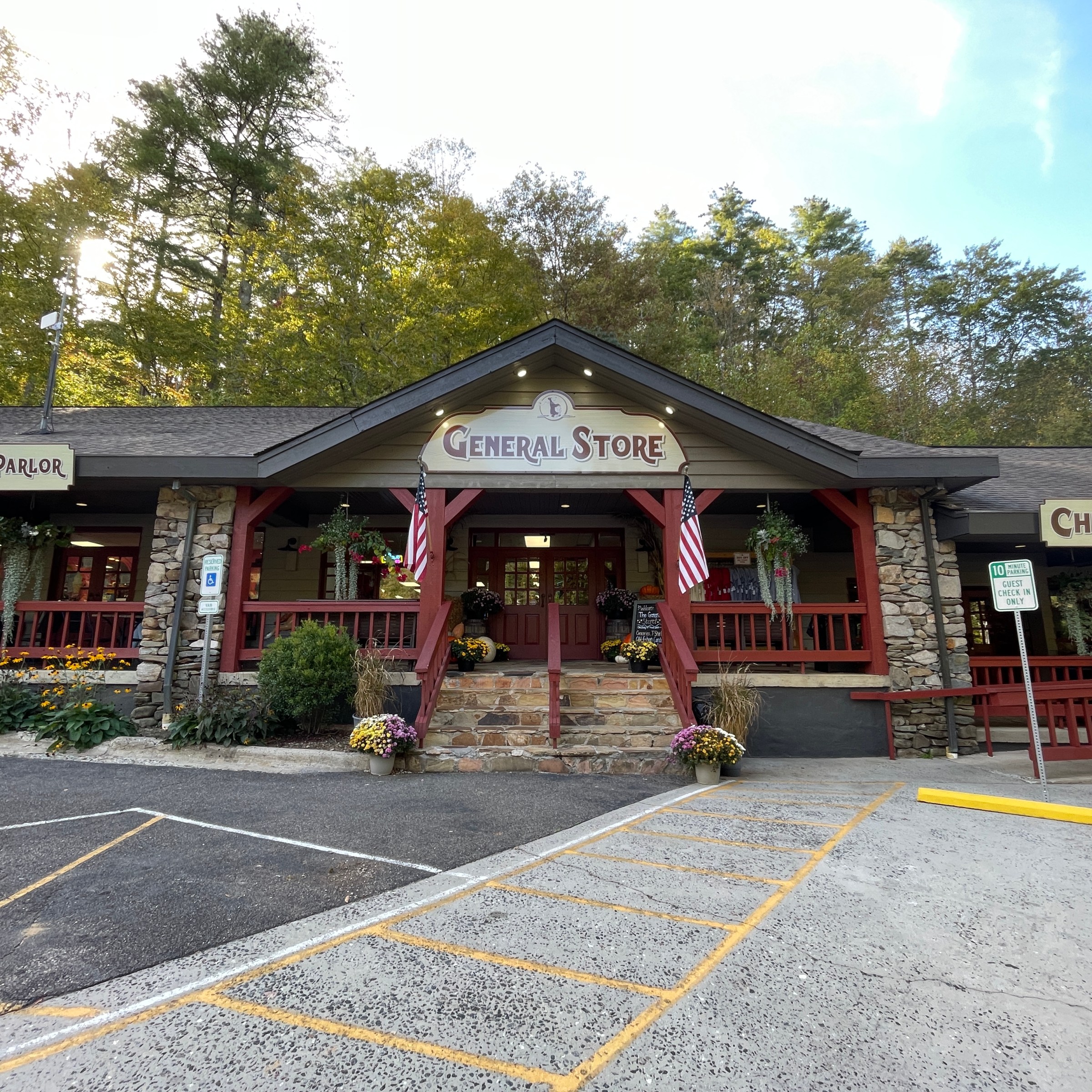 Rural general store with signs for ice cream parlor and check-in, surrounded by trees.
